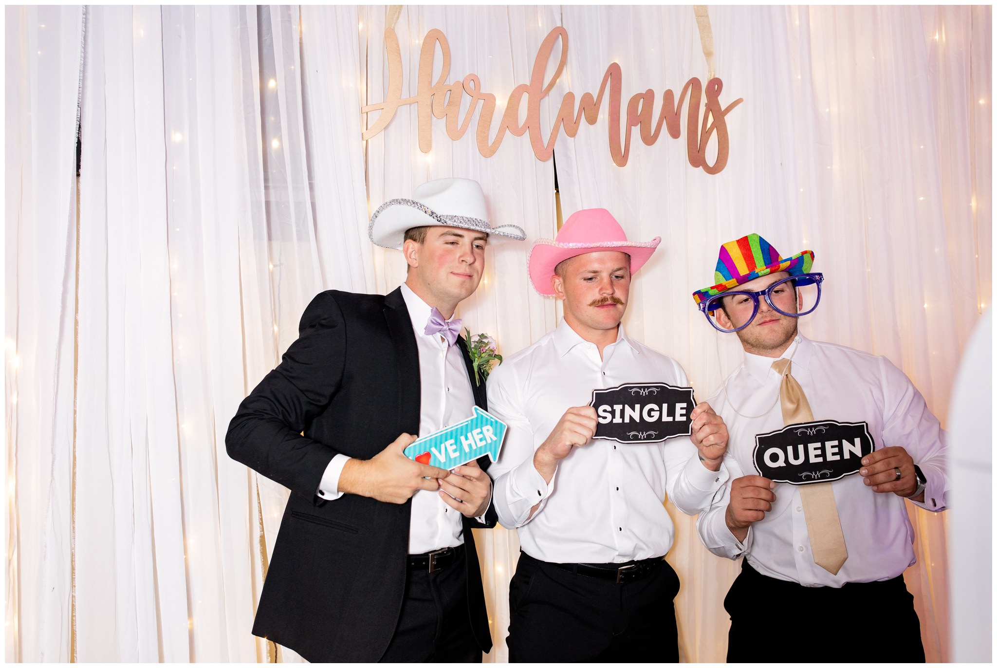 Groom and best friends taking pictures at photobooth