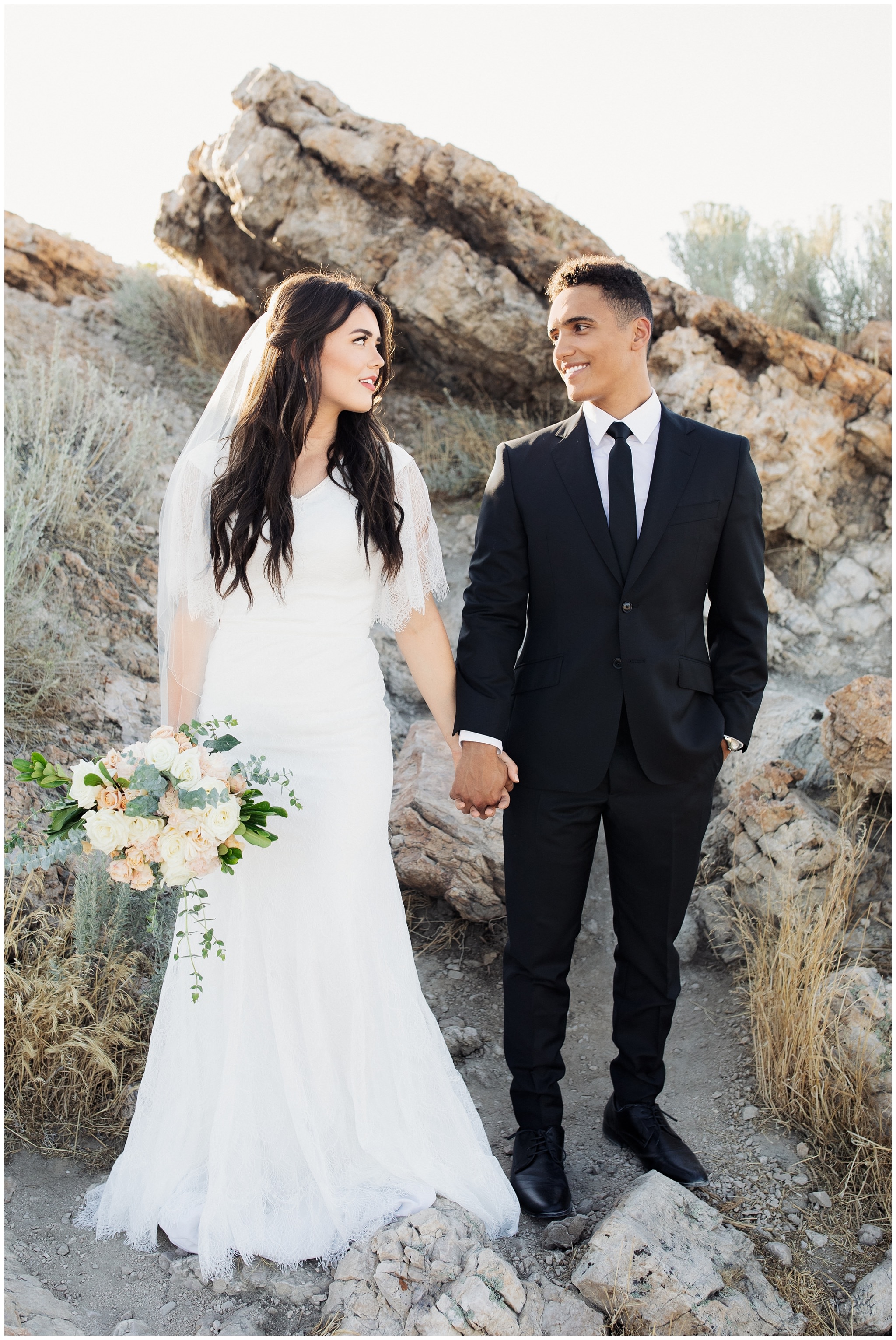 Bride and groom taking pictures at Ladyfinger Point at Antelope Island in Utah