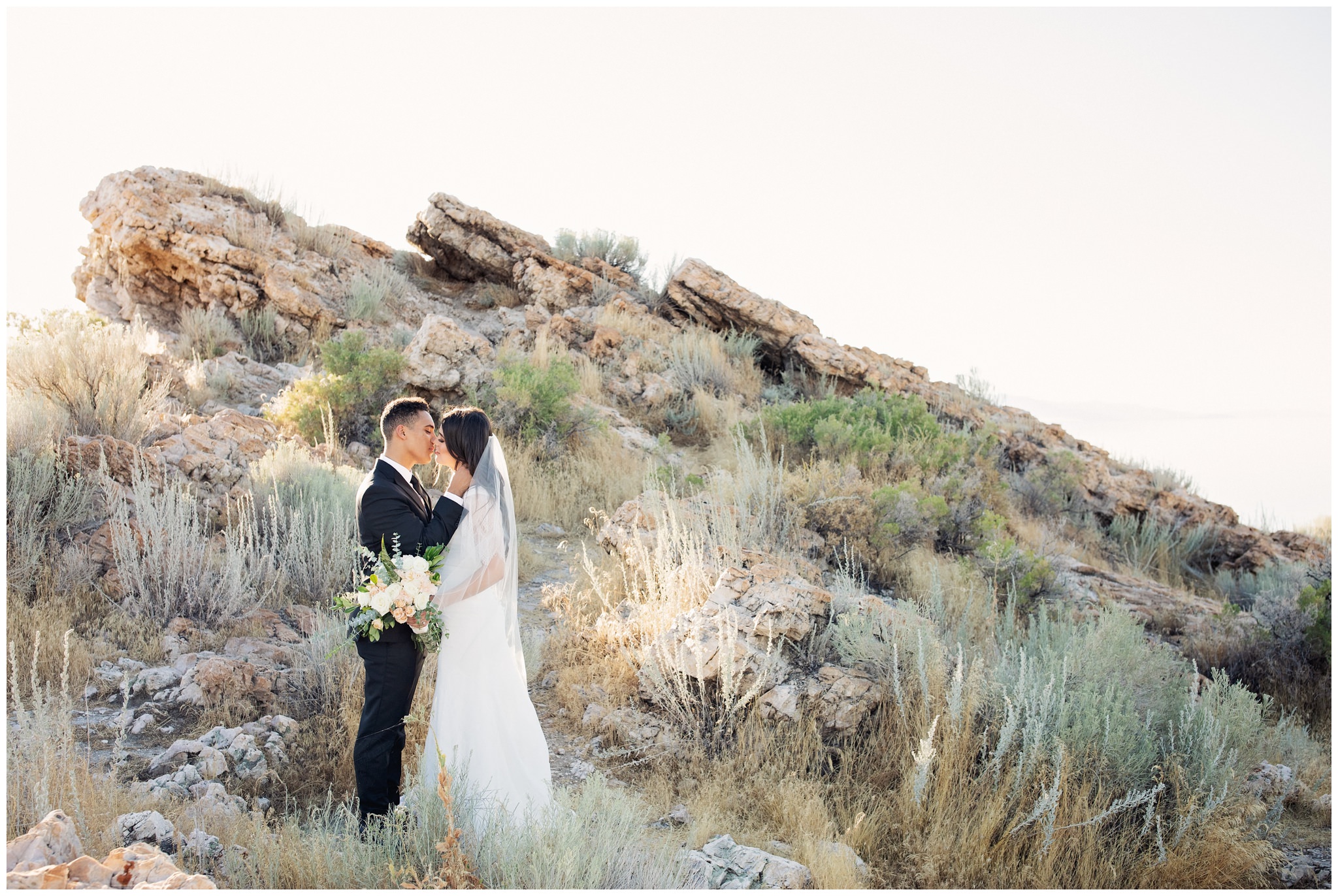 Antelope Island pictures of bride and groom near rocks and island