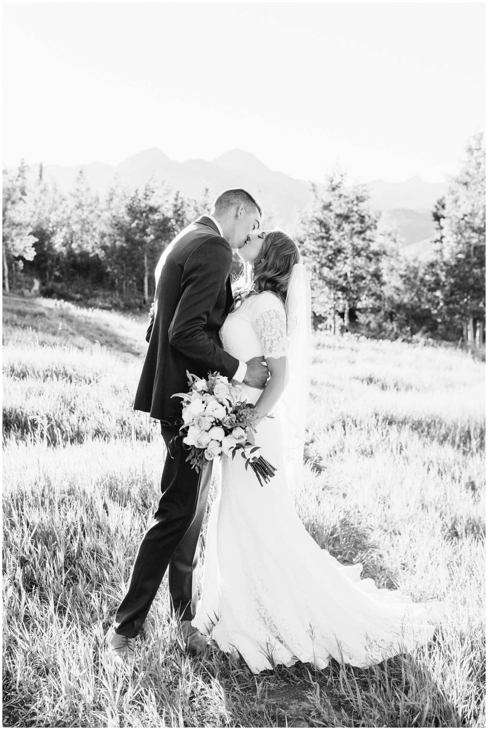 Bride and groom kissing near Aspen trees for their bridals