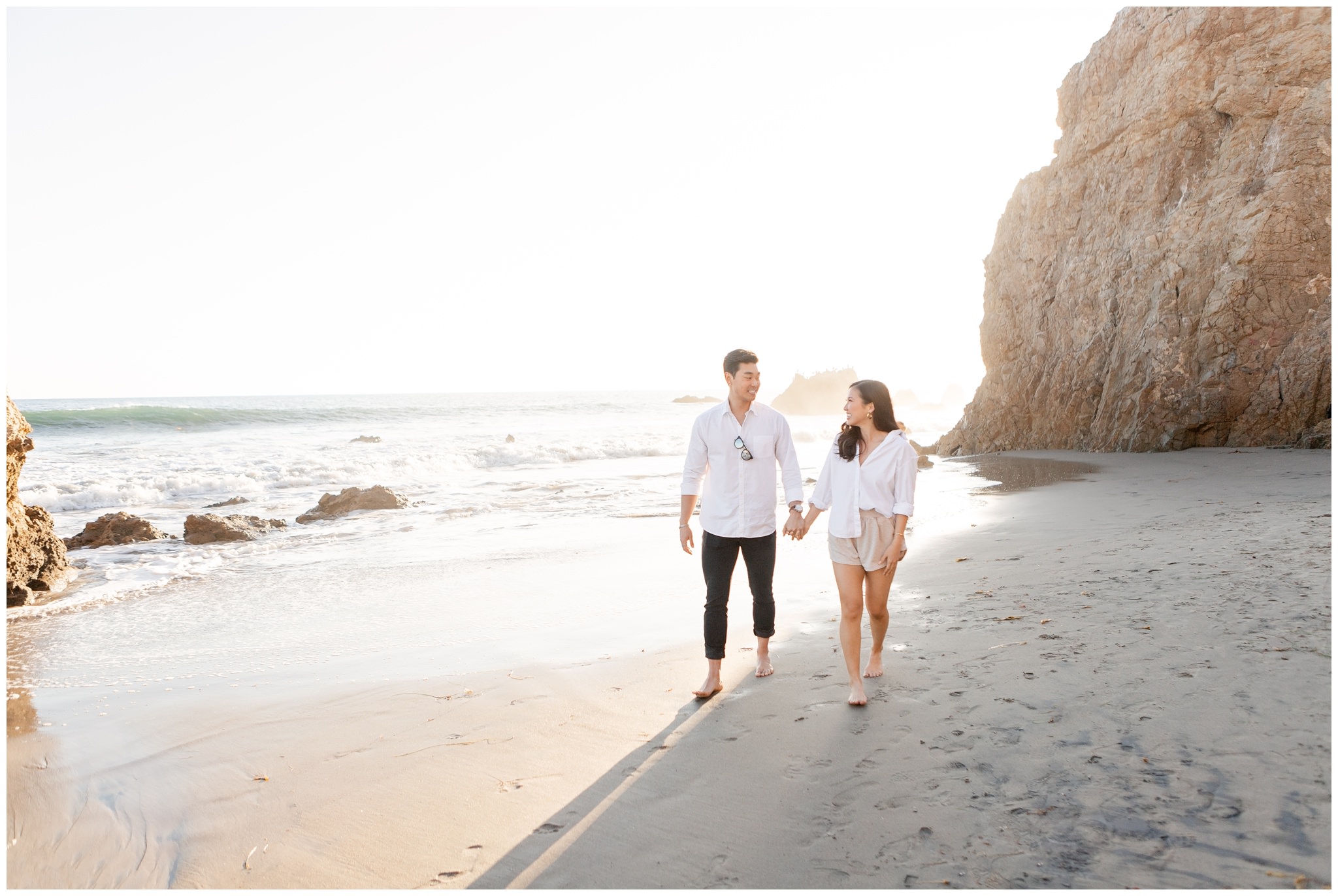 Couple walking on Malibu beach, CA