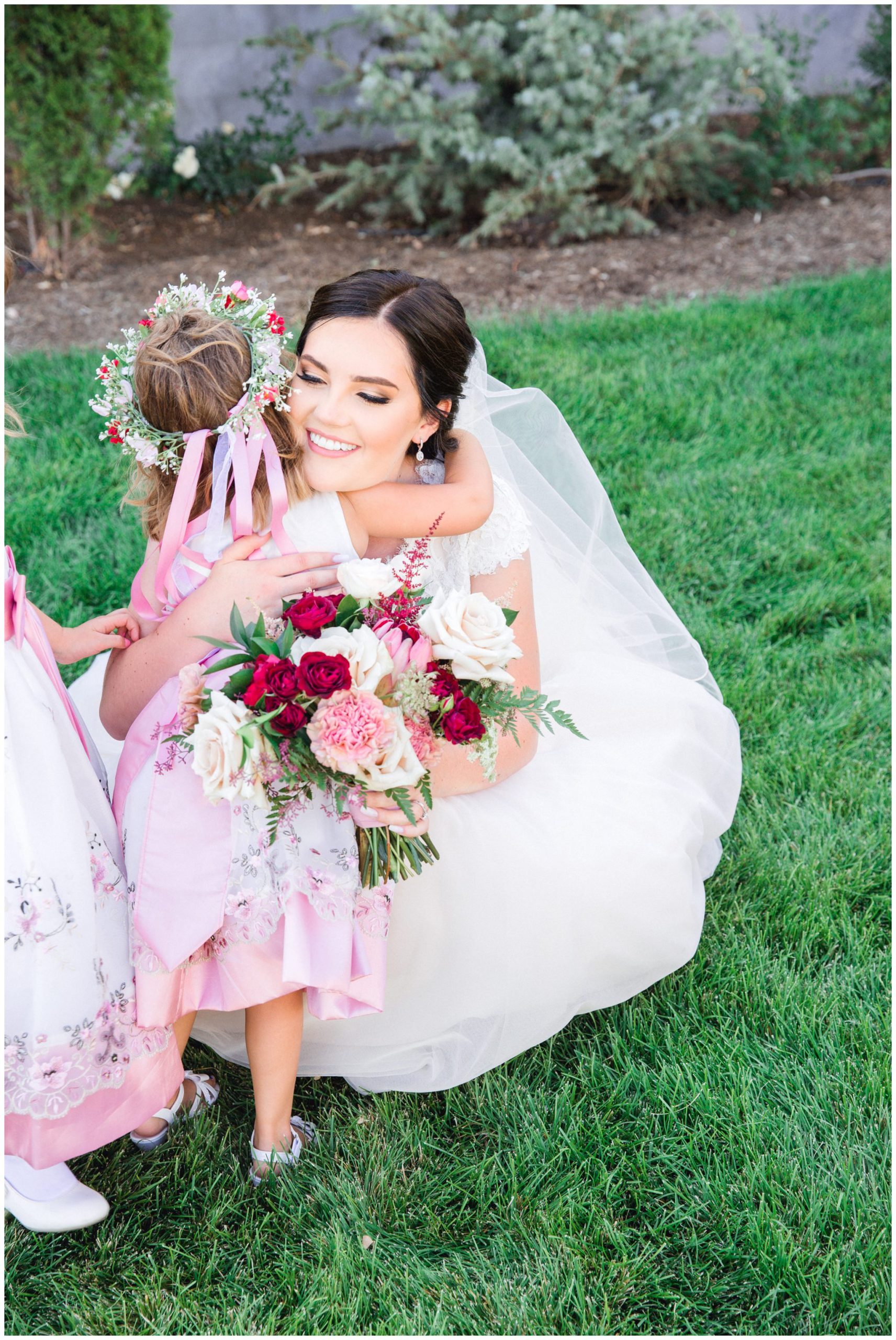 Bride hugging flower girl on wedding day at the Wild Oak wedding venue in Lindon Utah