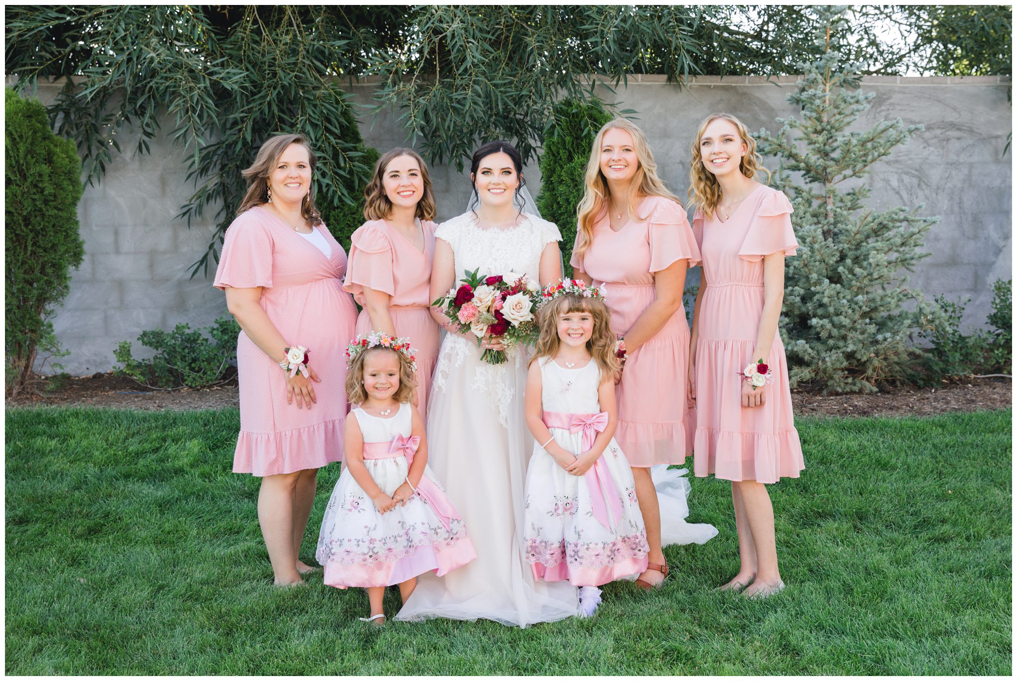 Bride posing with her bridesmaids and flowers girls at wedding in Lindon utah