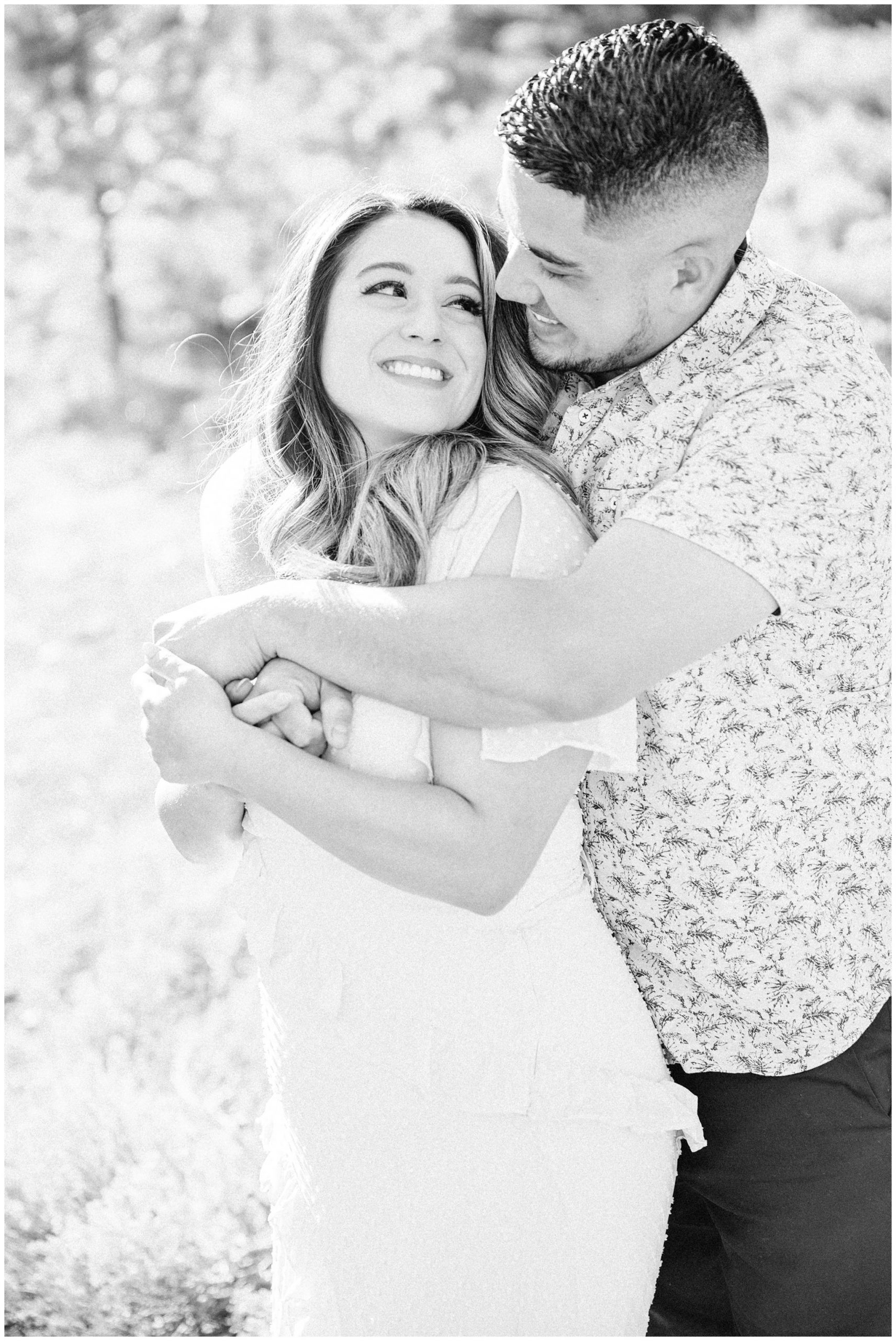 Couple hugging each other during their spring engagement session, black and white image of couple