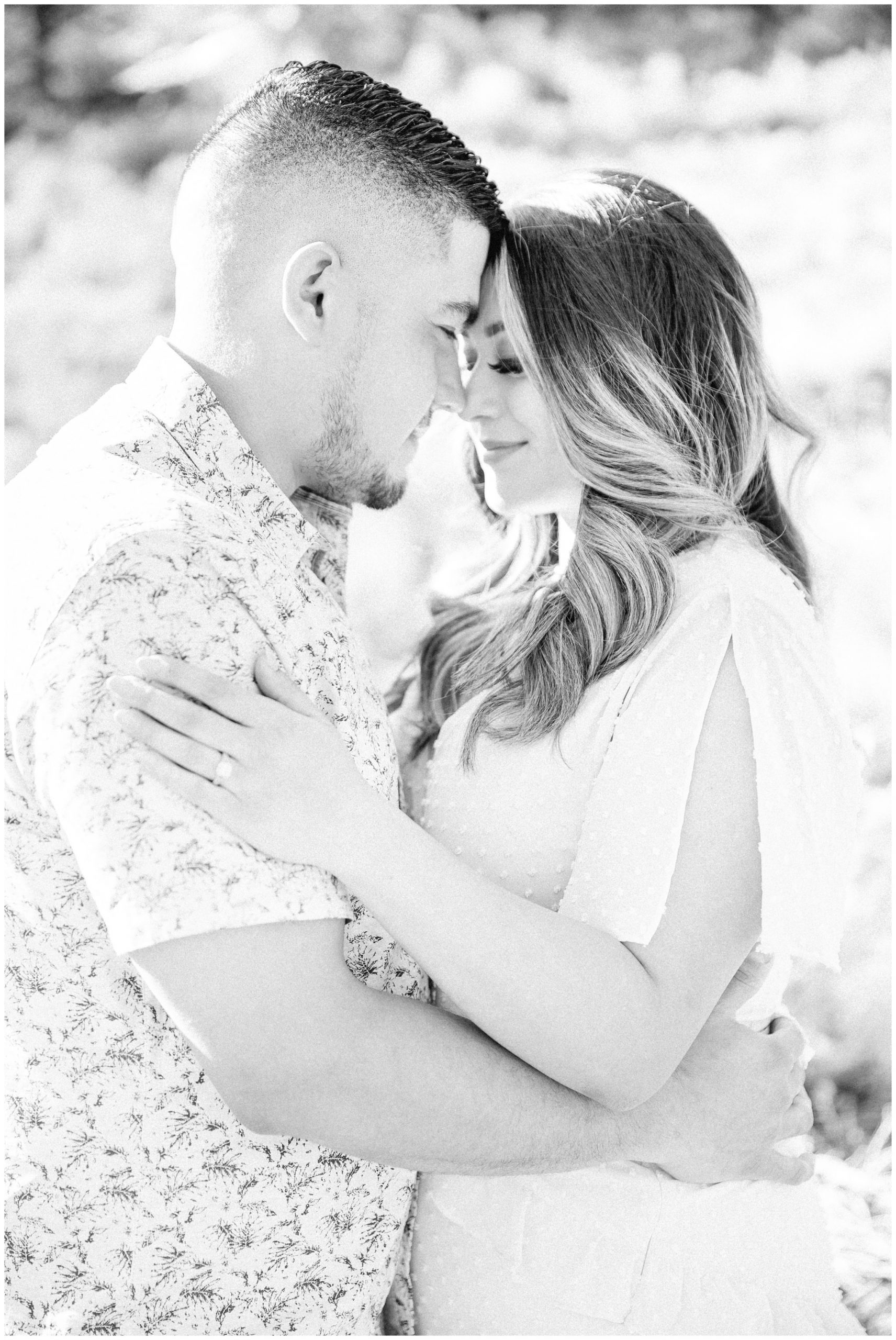 Black and white image of couple snuggling up to each other.