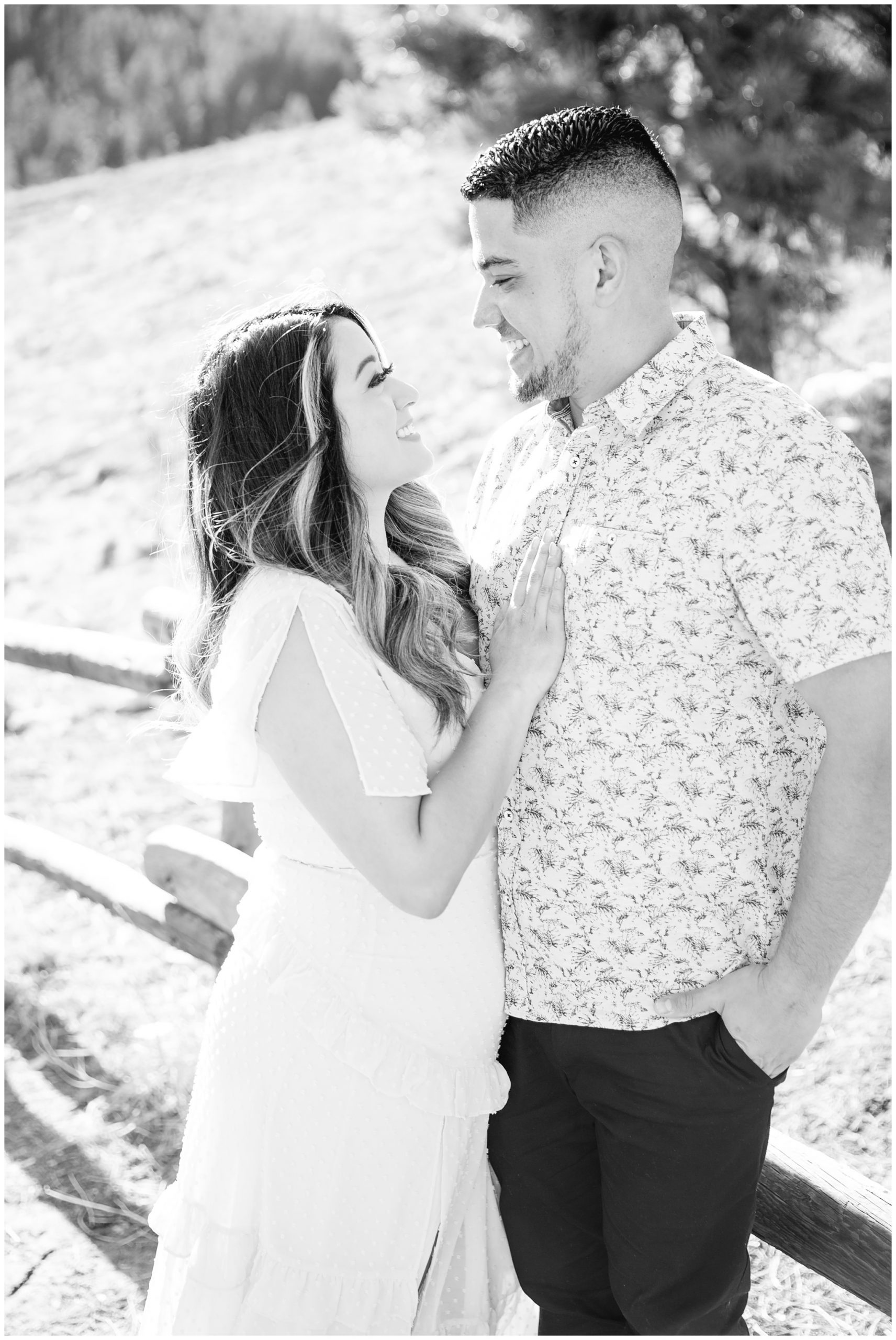 Black and white image of engaged couple smiling at each other