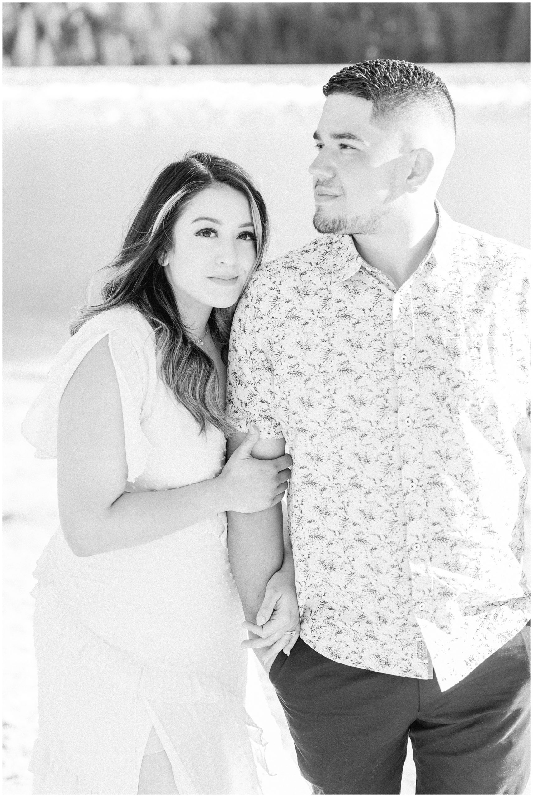 Black and white image of couple standing in the mountains of Utah near a lake