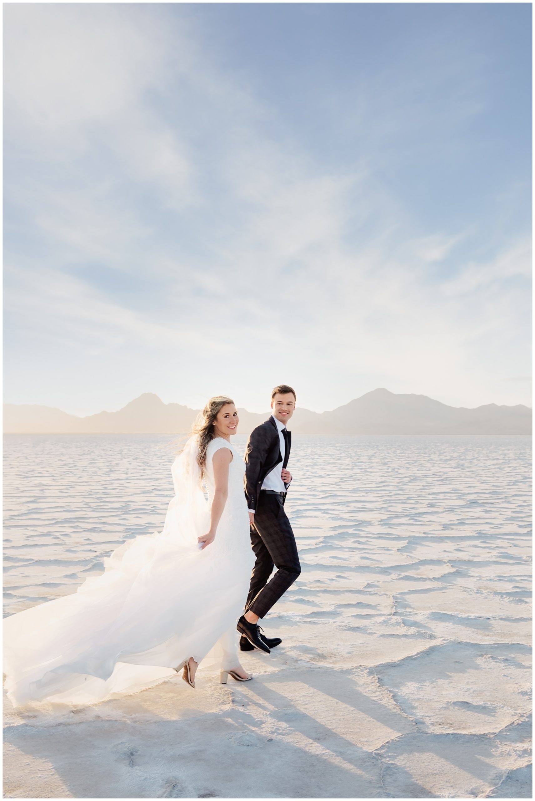 Utah Salt flats bride and groom taking pictures at sunset