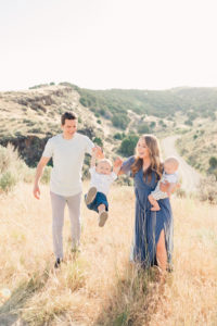Candid moment of a family in Lubbock Texas, Family pictures in rolling hills, mom and dad swinging brother for pictures in Texas