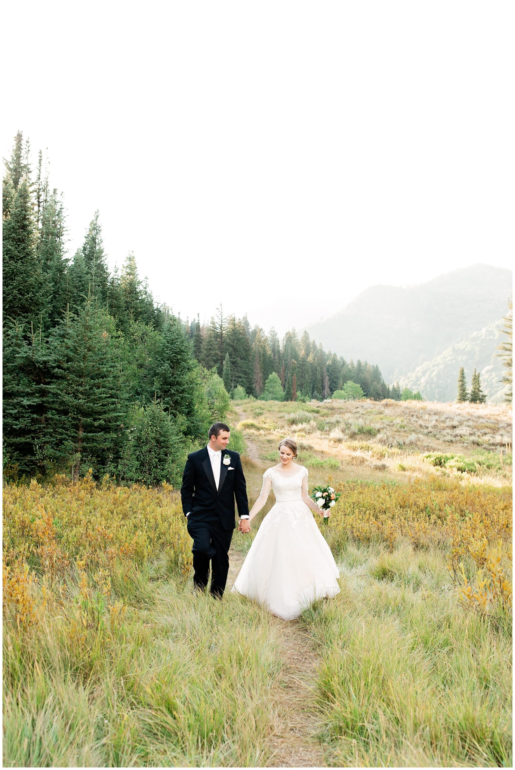 Bride and groom walking along a mountain trail in Utah