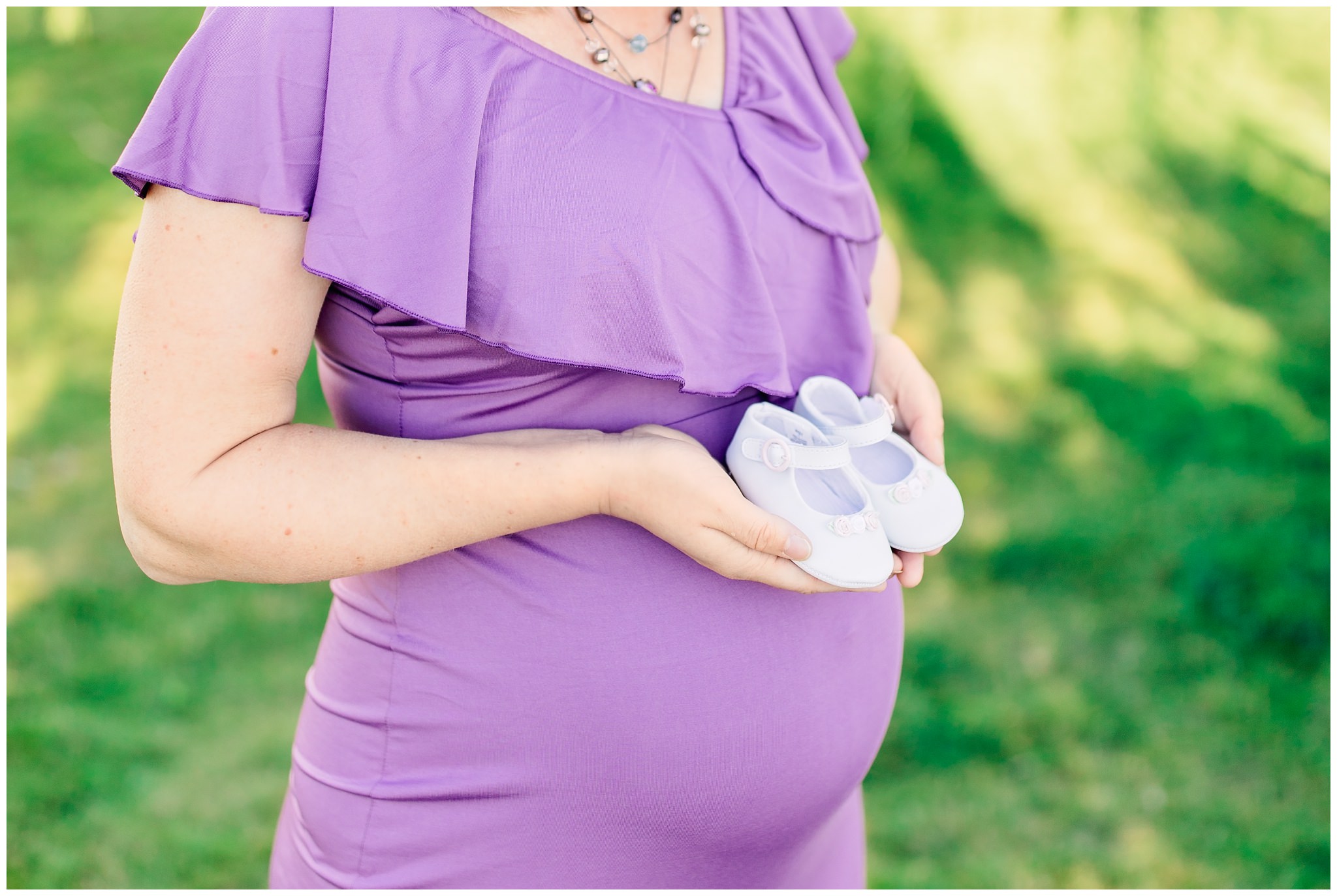 Mom holding baby girl shoes for maternity picture in Lubbock Texas