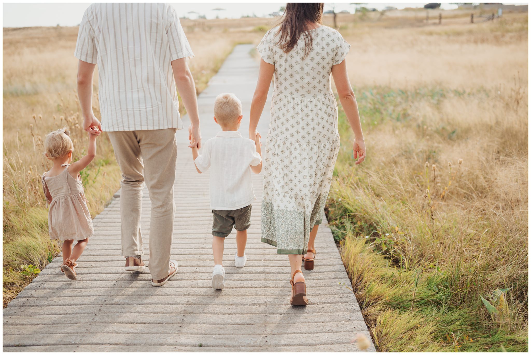 Family holding hands walking on a boardwalk at Lubbock Lake Historic Landmark